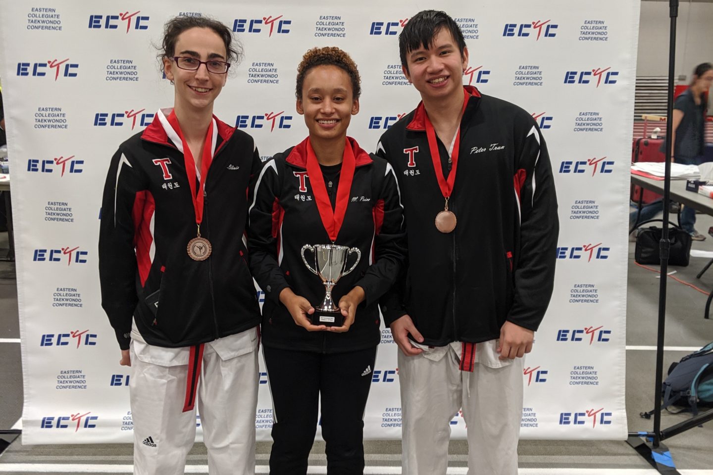 MIT sport taekwondo captains holding trophy at tournament