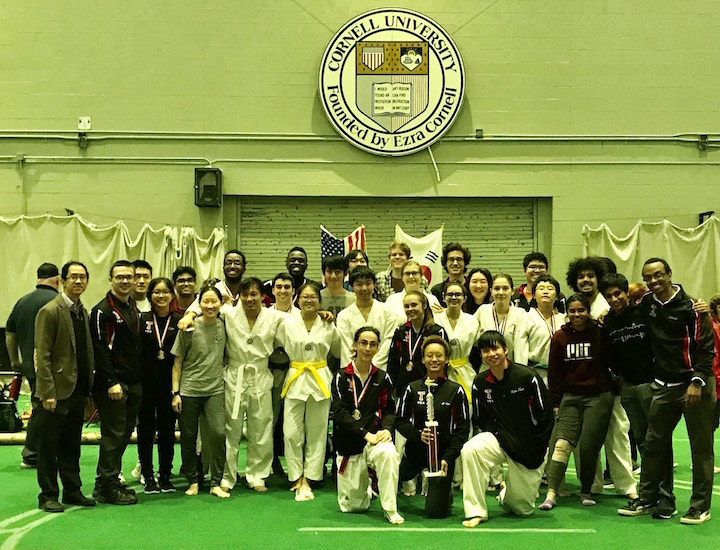 MIT sport taekwondo team posing with trophy at Cornell University