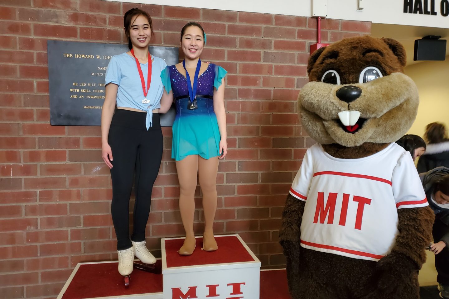 Figure skaters on podium with Tim the Beaver