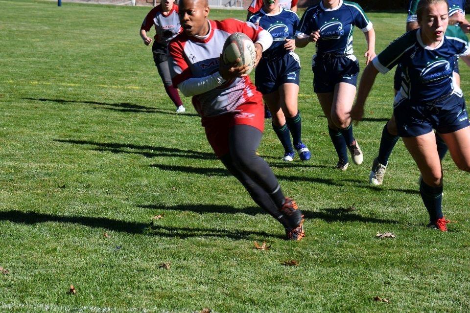 Women's rugby player running with ball