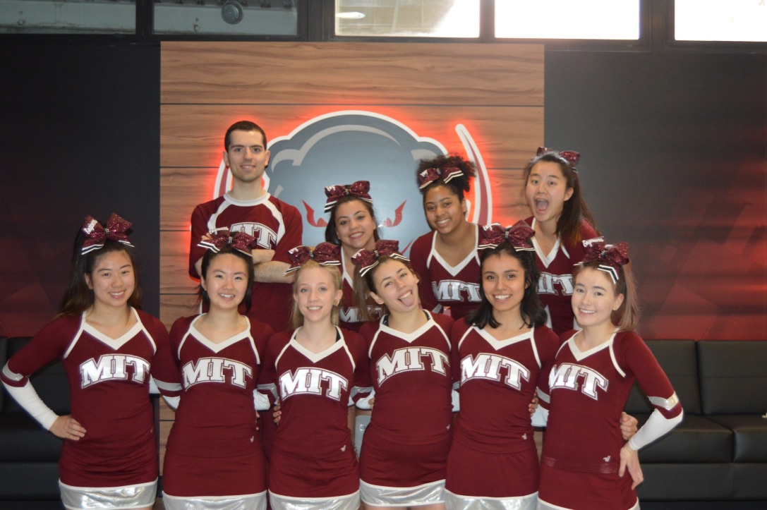 Cheerleaders posing in front of DAPER logo