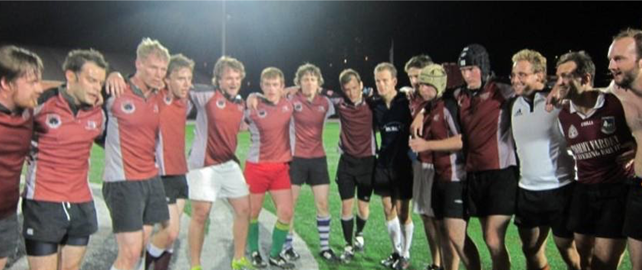 Men's rugby team with arms around each other