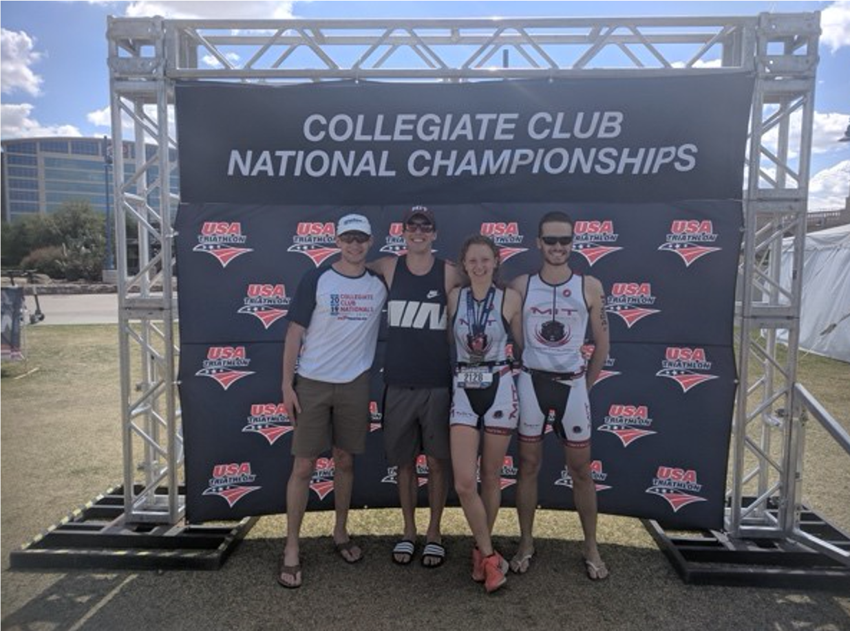 4 students in front of banner at nationals